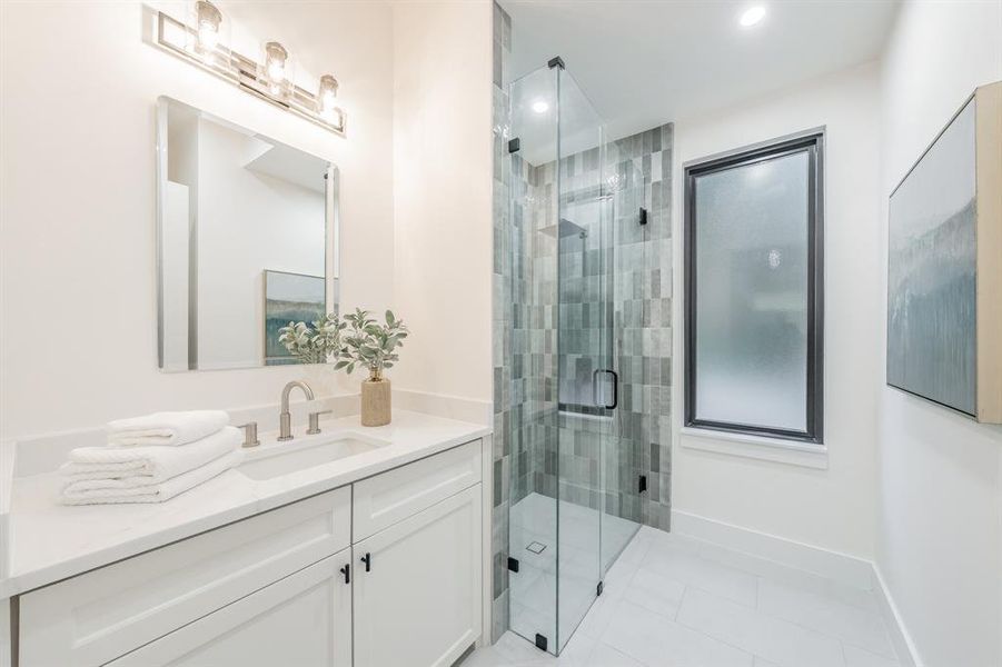 Bathroom with an enclosed shower, oversized vanity, and tile flooring