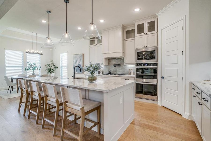 Kitchen featuring a large island, light hardwood / wood-style flooring, and pendant lighting