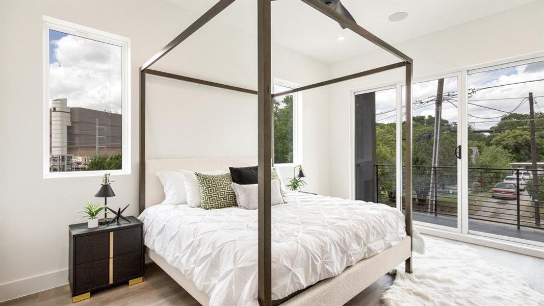 Bedroom featuring access to outside, hardwood / wood-style flooring, and multiple windows