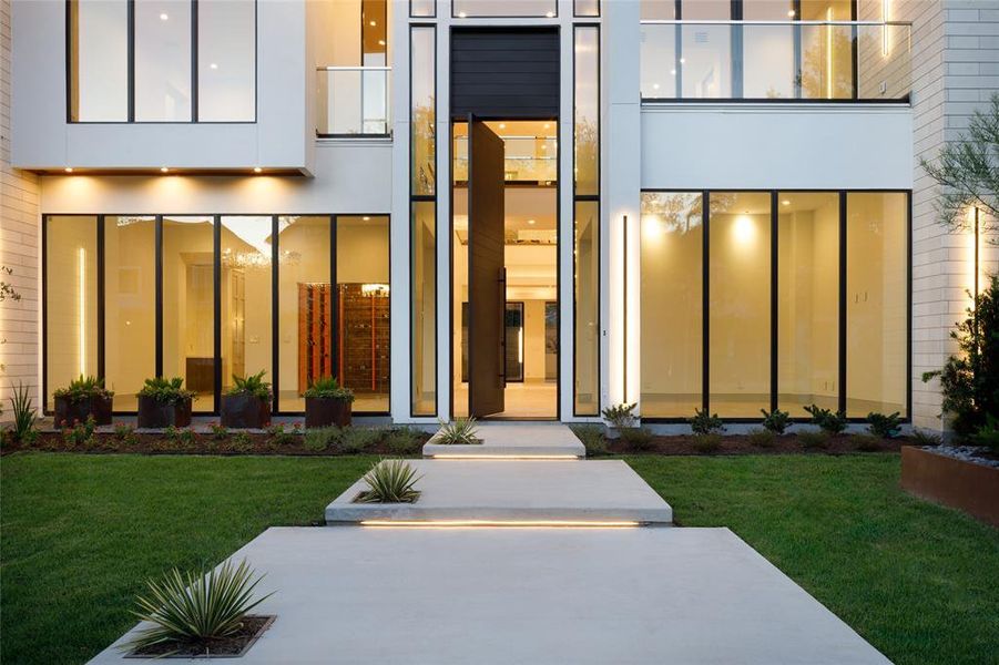 Custom-built 14' Steel front door with Pivot opening complimenting the home and ready to roll out the welcome mat