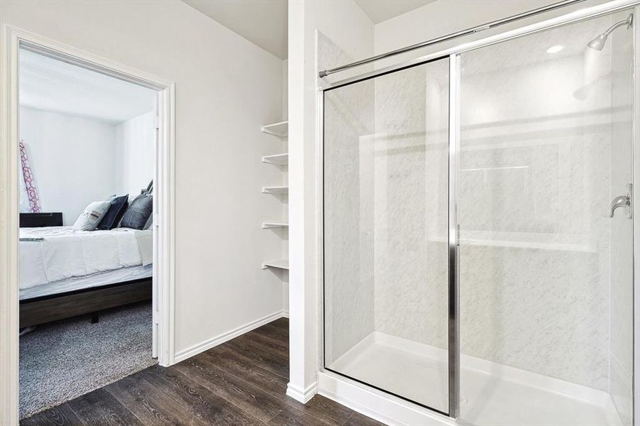 Bathroom with wood-type flooring and a shower with shower door