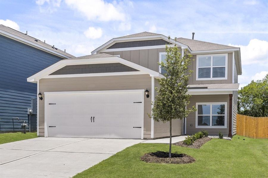 View of front of home featuring a front yard and a garage