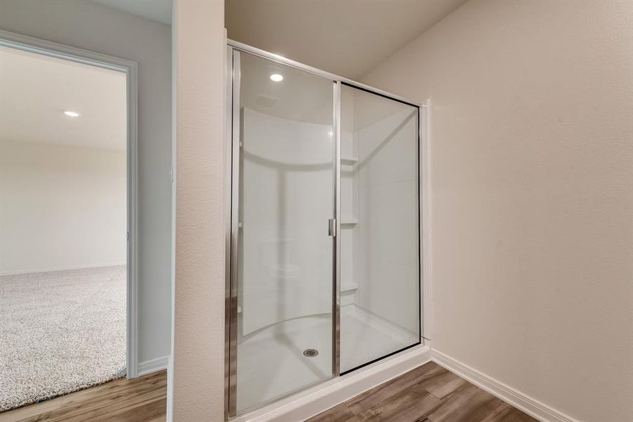 Bathroom with a shower with door and hardwood / wood-style floors
