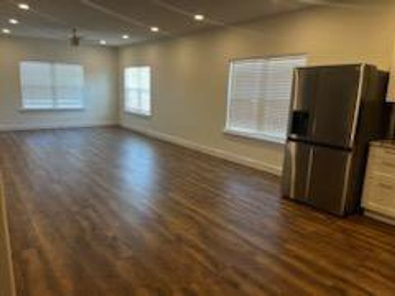 Kitchen featuring stainless steel fridge and dark hardwood / wood-style flooring