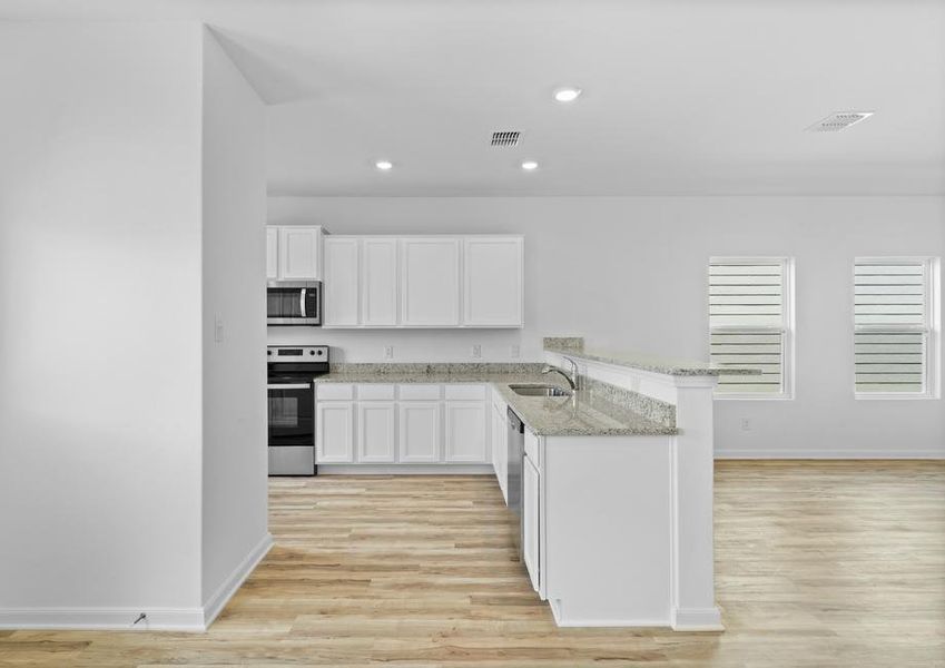 The kitchen features a long breakfast bar