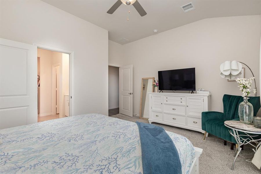 Bedroom with light carpet, vaulted ceiling, and ceiling fan