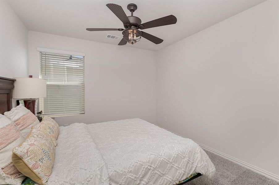 Carpeted bedroom with ceiling fan