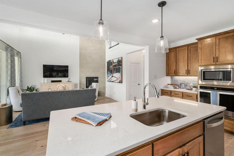 Kitchen featuring sink, light hardwood / wood-style flooring, decorative light fixtures, and stainless steel appliances