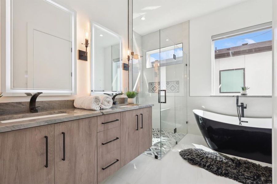 Bathroom featuring tile patterned floors, separate shower and tub, a wealth of natural light, and double sink vanity