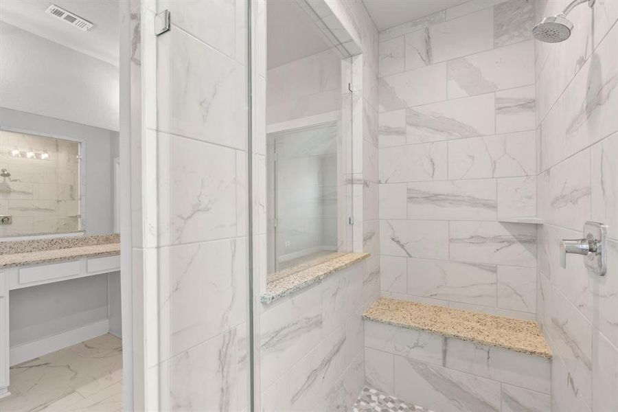 This additional view of the primary bath features a walk-in shower with bench seating. Sample photo of completed home with similar floor plan. Actual colors and selections may vary.