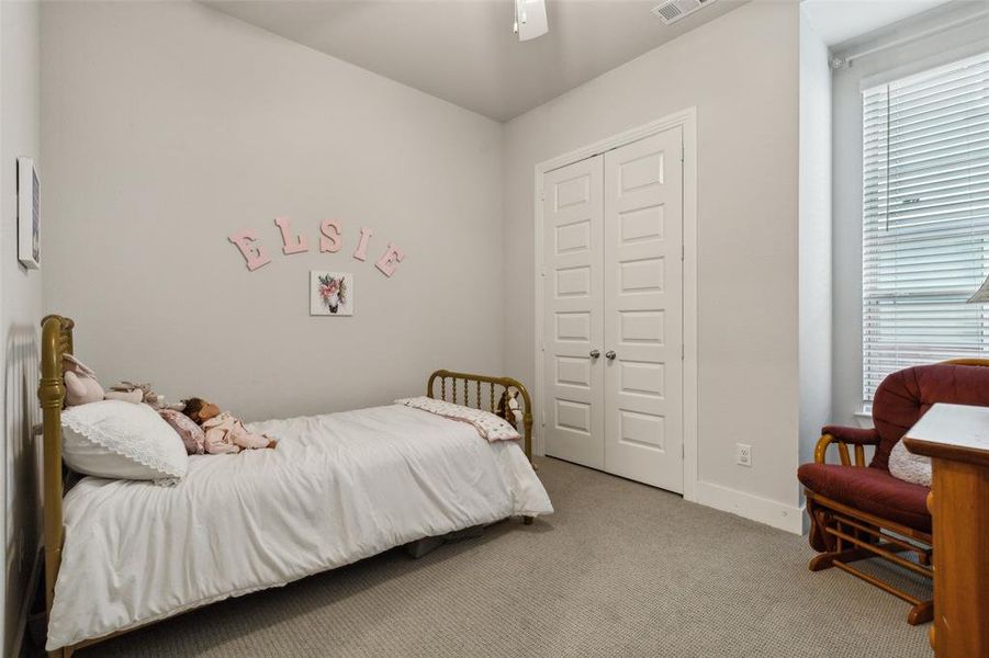 Second bedroom downstairs with ceiling fan, a closet, light textured carpet and en-suite bath.