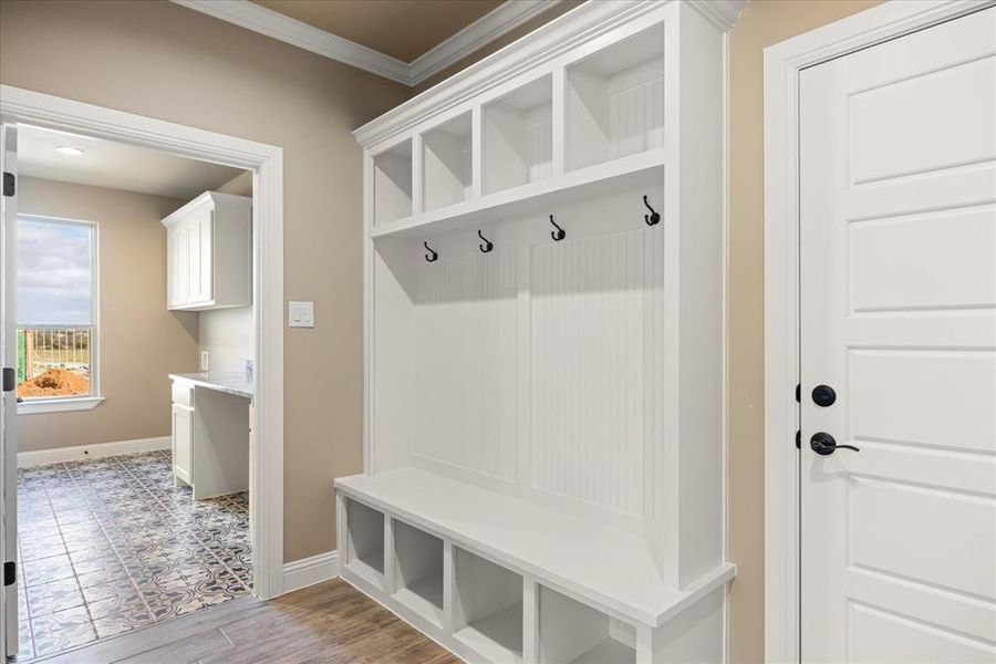 Mudroom featuring ornamental molding and light hardwood / wood-style flooring