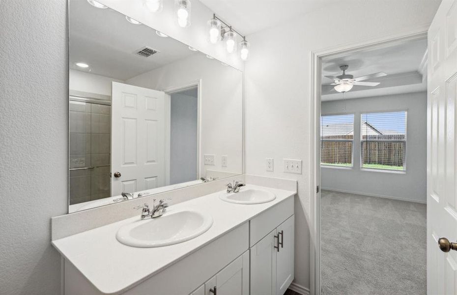 Owner's bath with double vanity and spacious shower*Real home pictured
