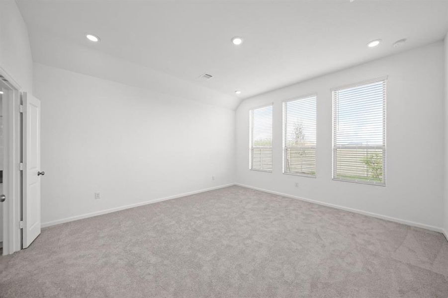 Primary/Master Bedroom with spacious windows with wood blinds and carpet and recessed lighting.