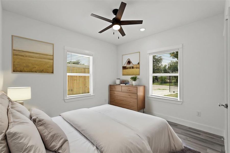 Virtually Staged: This Secondary Bedroom is located in the front of the house. It includes new vinyl floors, recessed lighting, and a ceiling fan. It is complete with a built-in closet.