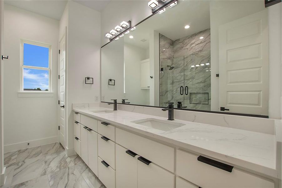 Bathroom with a shower with shower door, tile patterned flooring, and dual bowl vanity
