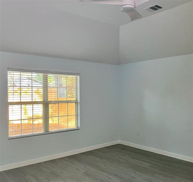 Unfurnished room with dark wood-type flooring and ceiling fan