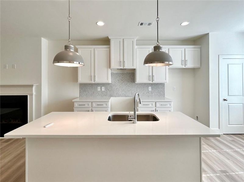 Kitchen with an island with sink and pendant lighting