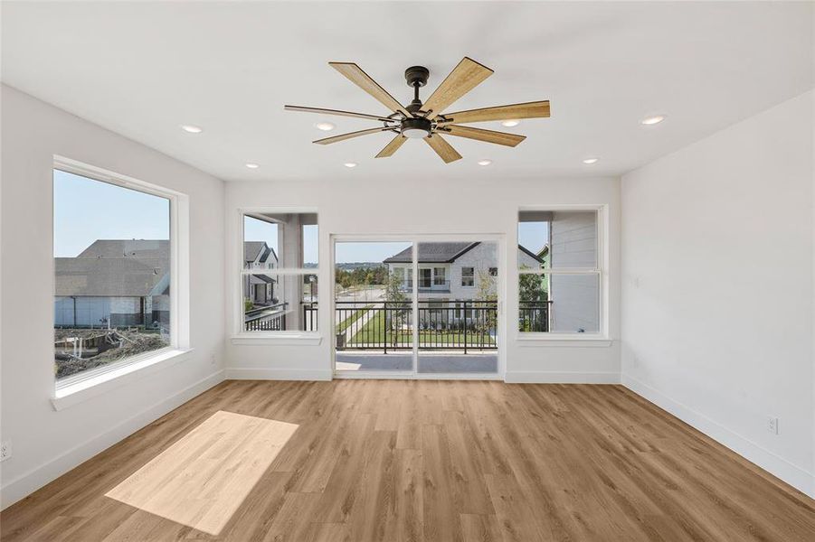 Spare room featuring a healthy amount of sunlight, light wood-type flooring, and ceiling fan