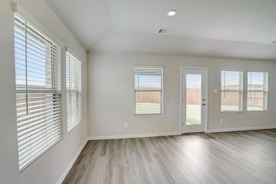 Living area featuring light hardwood / wood-style flooring, lofted ceiling, and a healthy amount of sunlight