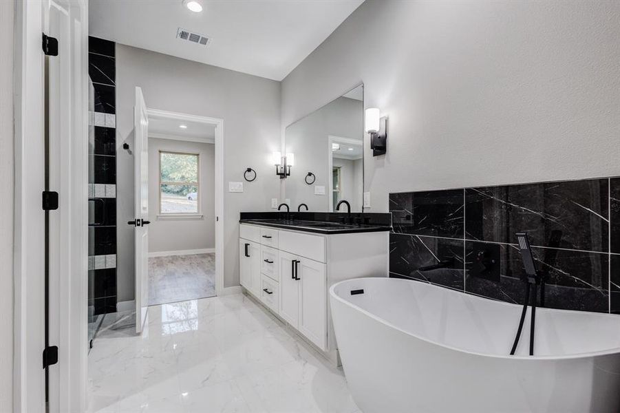 Primary Bathroom with a soak tub, tile patterned floors, and vanity