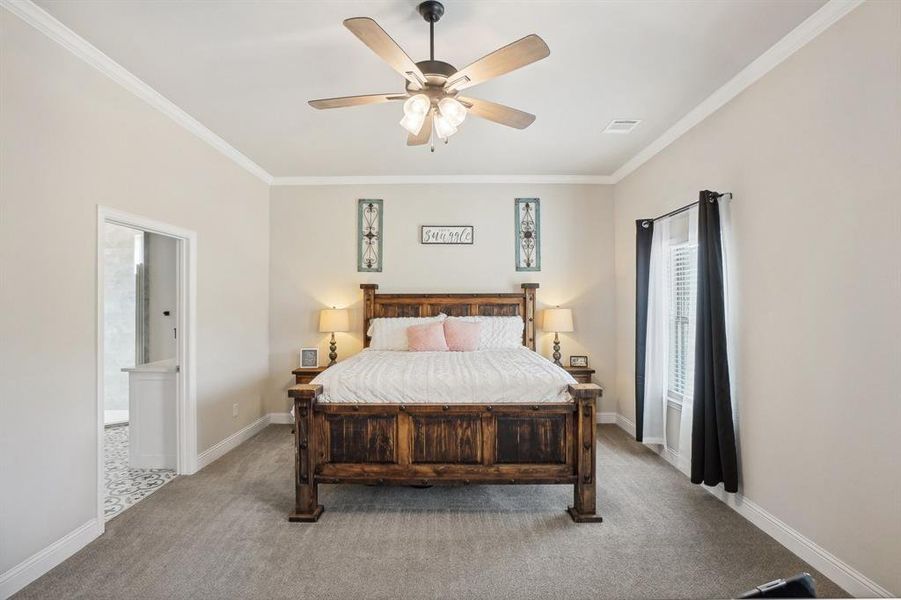 Bedroom featuring ornamental molding, ceiling fan, light colored carpet, and ensuite bathroom