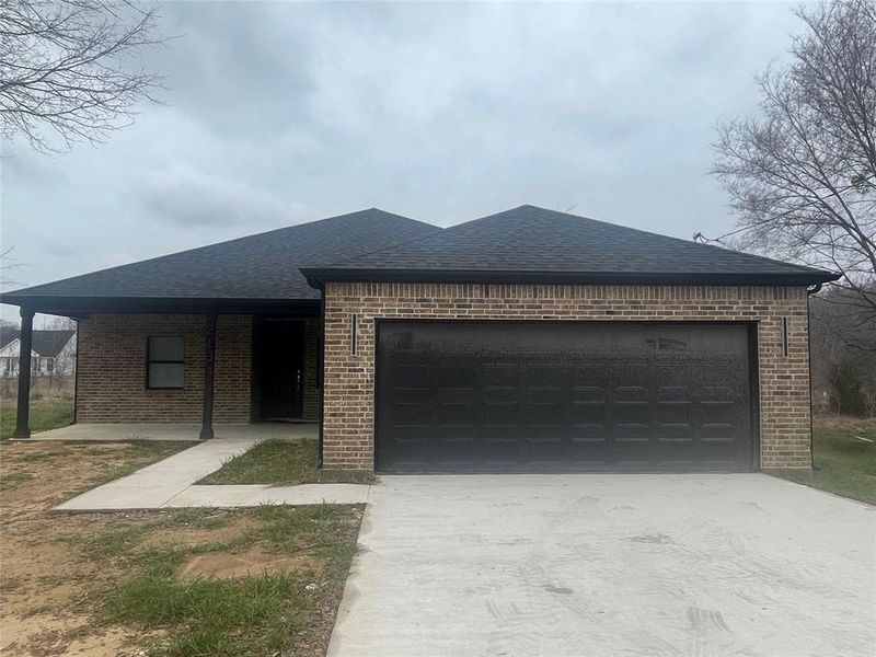 View of front of property featuring a carport and a garage