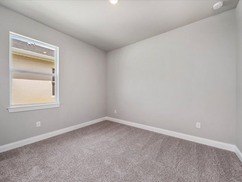 Bedroom in the Coral floorplan at 6326 NW Sweetwood Drive in Brystol at Wylder