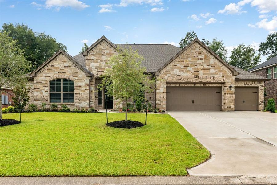 Welcome home to 998 Briac Lane located on a quiet lot in Stewart's Forest and zoned to Conroe ISD! This stunning Sitterle Home has lovely curb appeal, with a well-manicured lawn, beautiful landscaping, stone/brick elevation, dark stained front door with glass detailing, covered front porch, and an oversized driveway!