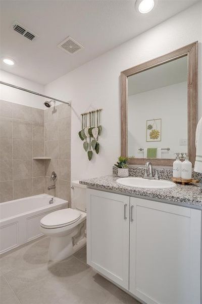 Full bathroom with tile flooring, vanity, toilet, and tiled shower / bath combo