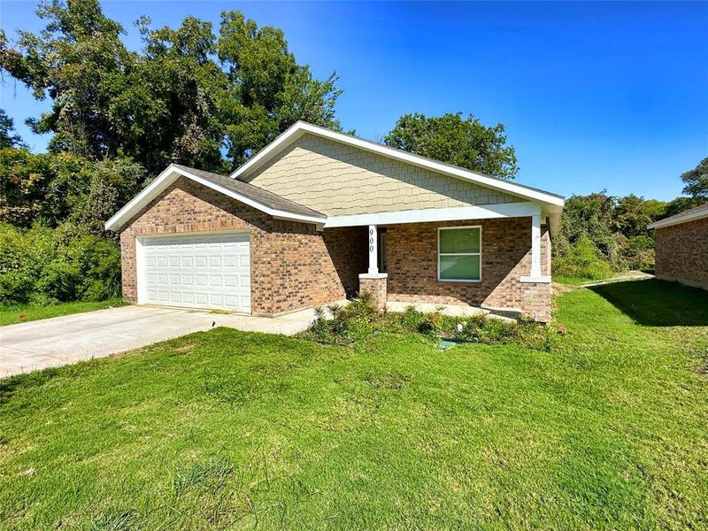 View of front of property featuring a front yard and a garage