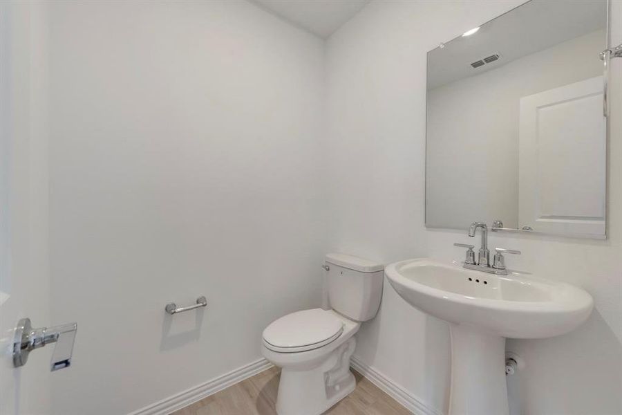 Bathroom featuring hardwood / wood-style floors and toilet