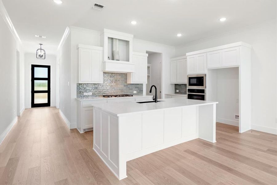 Kitchen featuring sink, stainless steel appliances, and white cabinetry