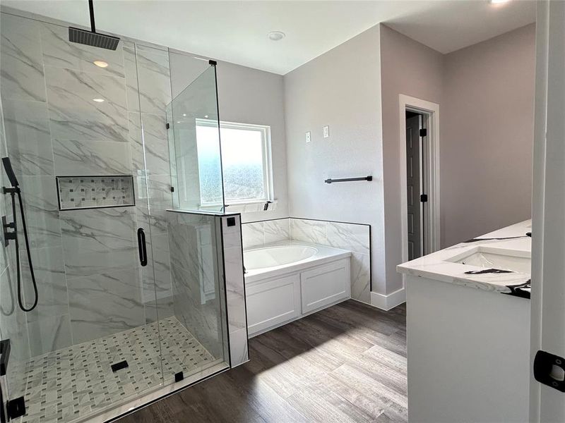 Bathroom with hardwood / wood-style flooring and independent shower and bath