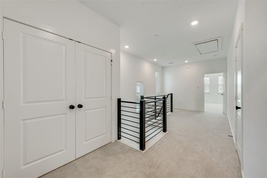 Hallway featuring light carpet