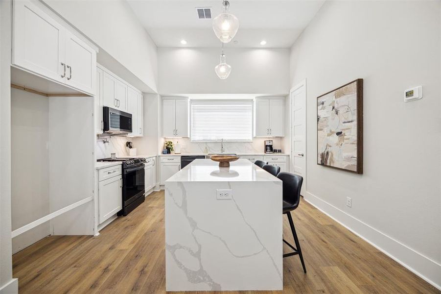 The large kitchen island has outlets on either side to make food prep a breeze. (Refrigerator will be installed soon.)