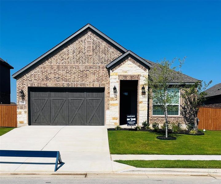 Our beautiful Kendall floor plan comes with a long driveway, a cedar garage door, and lush front yard landscaping.