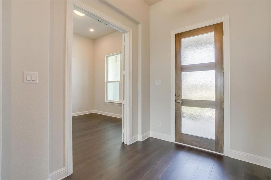 Doorway with dark hardwood / wood-style floors