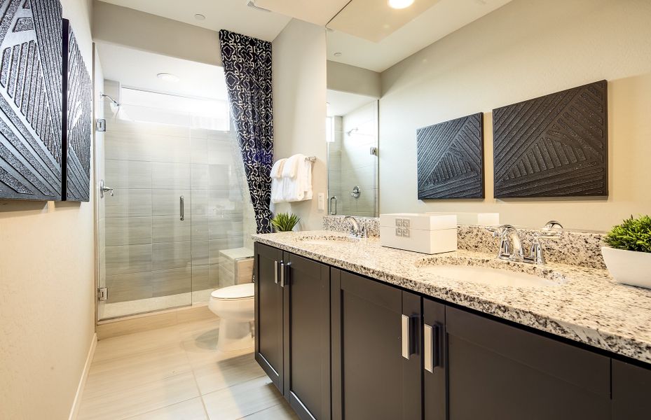 Owner's bathroom with dual vanity sinks and glass