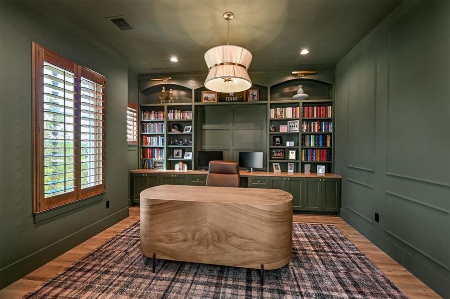 Sophisticated study with elegant built-ins, intricate wainscoting, and ambient lighting.