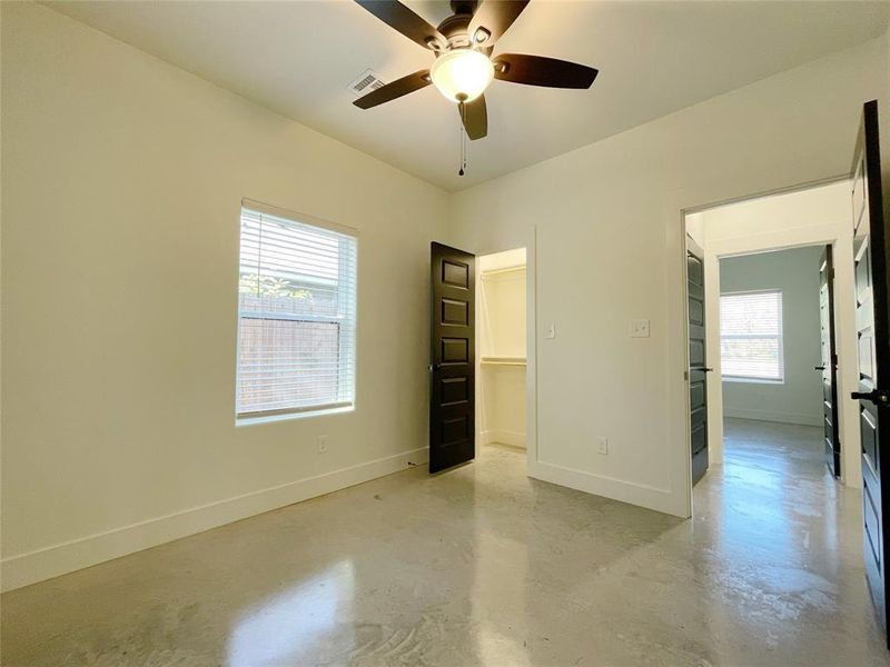 Unfurnished bedroom featuring a spacious closet and ceiling fan