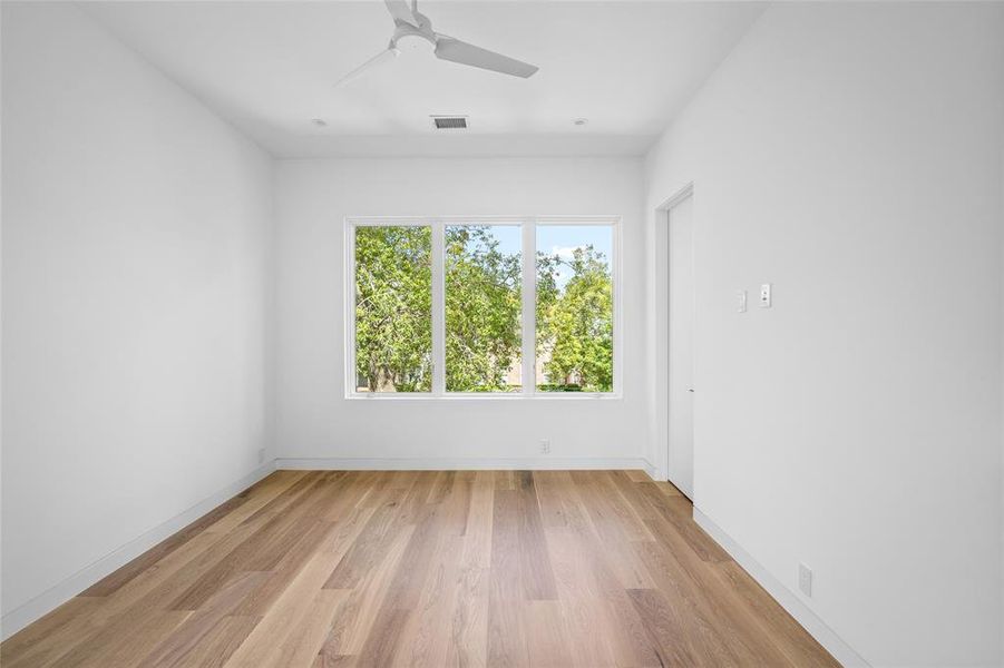 This inviting front secondary bedroom features sleek, 7 inch white oak hardwood flooring, a spacious walk-in closet and a private ensuite bath, offering both comfort and convenience.