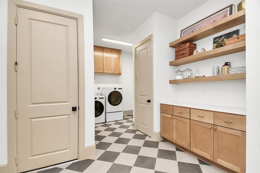 This well equipped mudroom/laundry connects to the garage, primary closet and common area (foyer area).  This room features an abundant amount of storage with 2 closets, cabinets/shelving and seating bench with built-in cubbies.  Already plumbed, a sink can easily be installed within the counter!