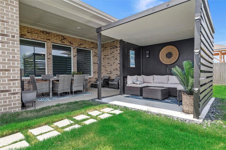 Inviting Outdoor Living - Extended patio with room for a long table, extra seating options, and a pergola. Lovely landscaping and pavers enhance the space.