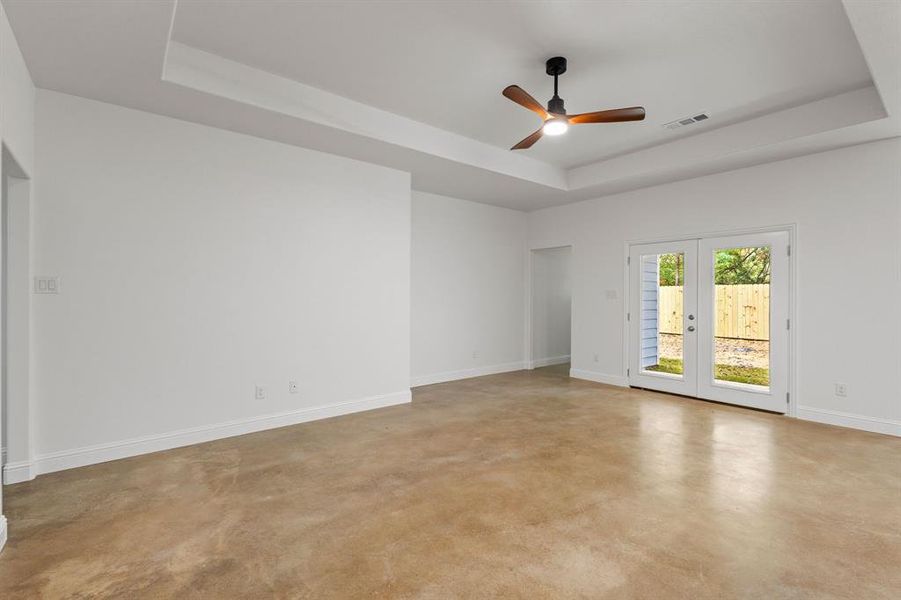 Unfurnished room with french doors, a tray ceiling, and ceiling fan