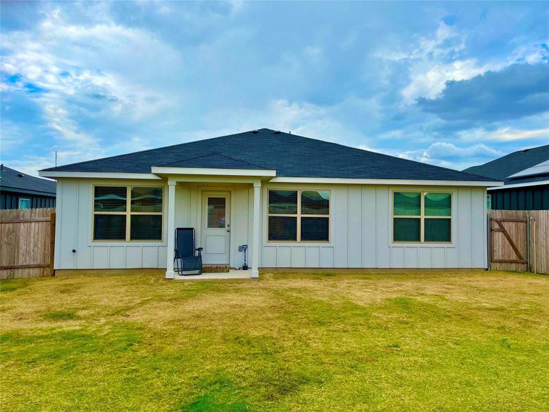 Back of home with covered porch area.