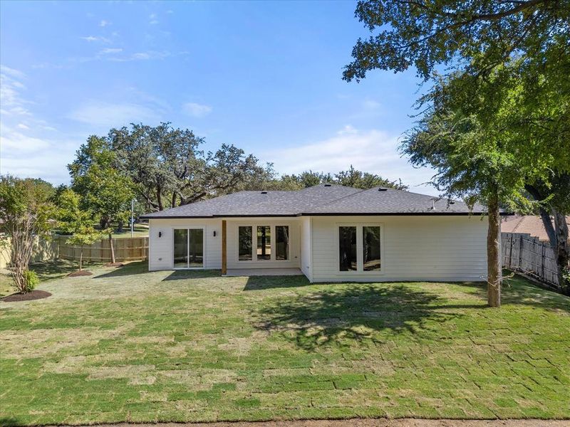 Rear view of property with a lawn