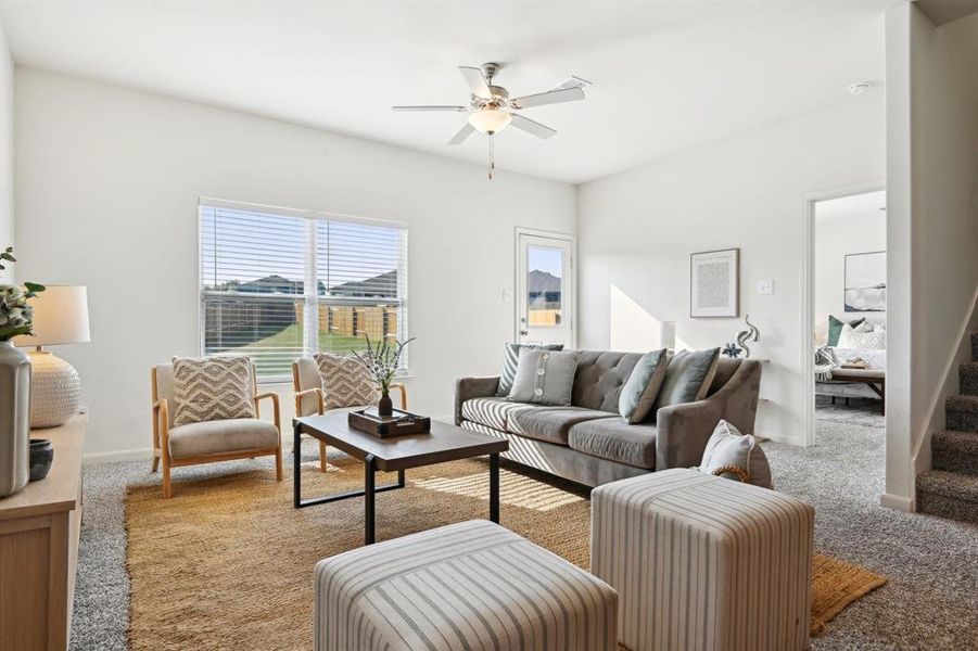 Living room featuring ceiling fan and carpet