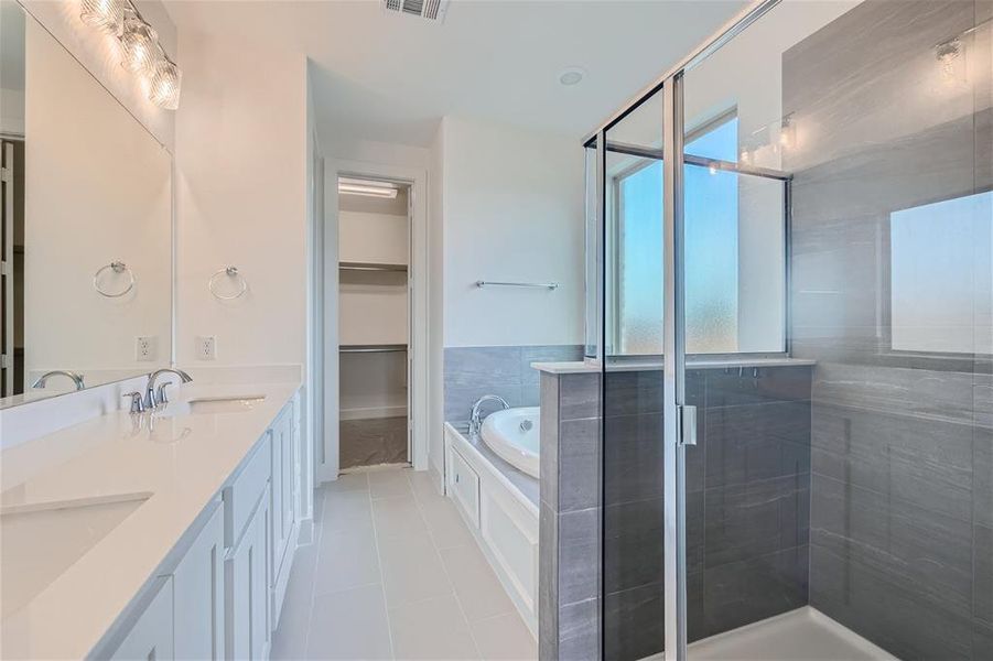 Primary en suite bathroom with vanity, separate shower and tub, and tile patterned floors