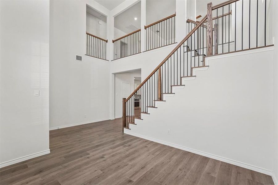 Staircase featuring wood-type flooring and a high ceiling